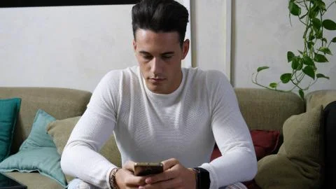 Young man typing and using cell phone Stock Photos