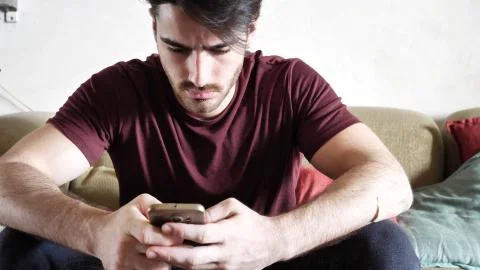 Young man typing and using cell phone Stock Photos