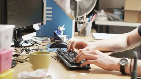 Young Man Typing on the Keyboard. Mess on the Desk Stock Footage 79078133