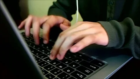 Young Man typing on a laptop computer Stock Footage 81894837