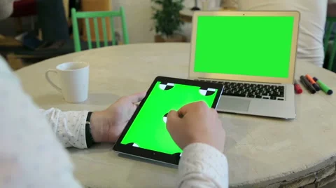 Young man typing on a laptop with a tablet Stock Footage 62802781