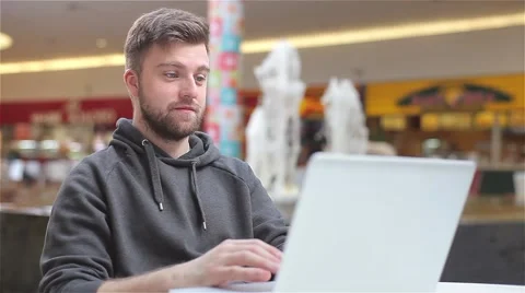Young Man Typing a Message on a Laptop and Laughing. Stock Footage 47977558
