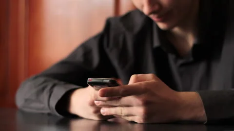 Young man typing on mobile phone. Shot with slider shot. Stock Footage 2913620