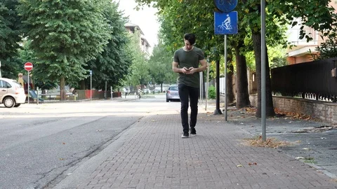 Young man typing on smartphone outside Stock Footage