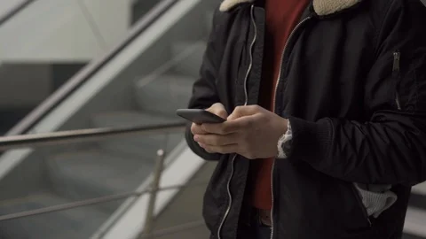 Young man typing on smartphone, smiling and walking away Stock Footage 124524565