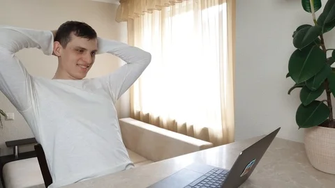Young man is typing something on a laptop, then leans back, concept telework Stock-Footage 126222738