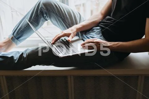 Young man typing something on a laptop Stock Photos