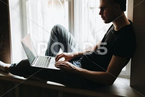 Young man typing something on a laptop Stock Photos