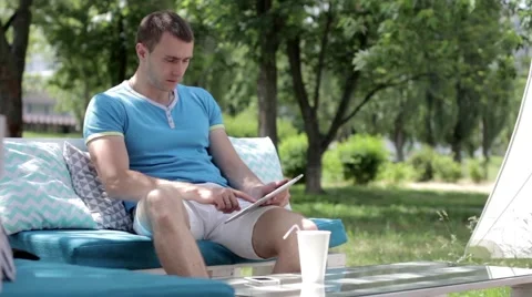 Young man typing on the tablet in nature Stock-Footage 65156290
