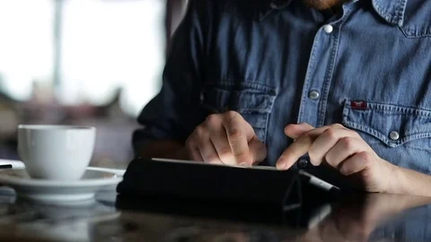 Young man typing on a tablet while sitting at the bar Stock Footage