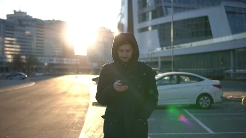 Young man typing text message on mobile phone on street in autumn Video stock 93335639