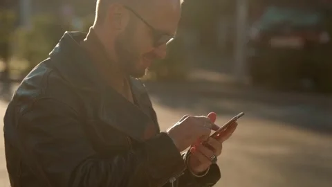 Young man typing text on a smartphone phone outdoor in the city street Video stock 161083315