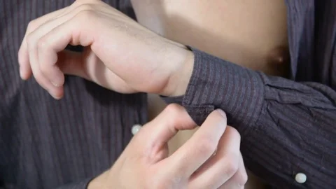 Young man unbuttoning and removing shirt Stock Footage 71066973