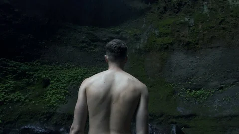 Young man under the waterfall, Indonesia, Bali. Near a waterfall on near Tropica Stock Footage 126696690