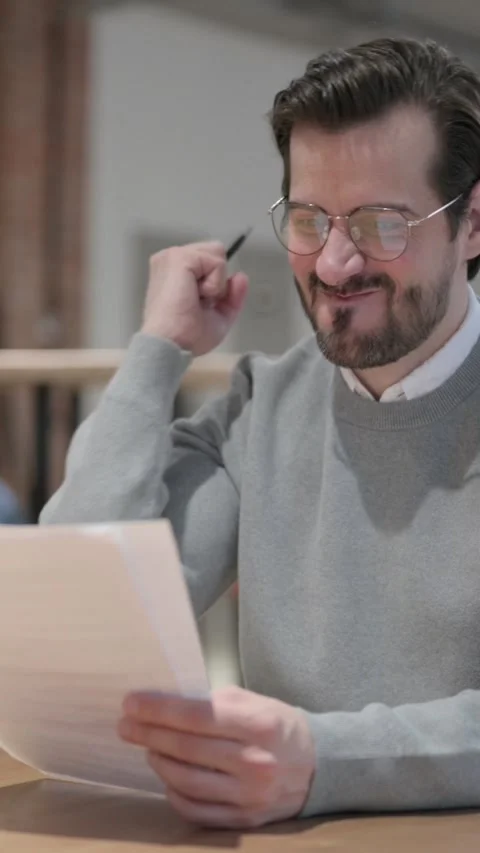 Young Man Upset while Reading Documents in Office, Vertical Video Stock Footage 339581066