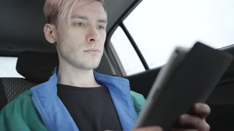Young man use graphic tablet in a taxi 스톡 동영상 194141737