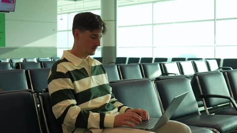 Young Man Use Laptop while waiting, airport terminal, work on computer Stock Footage 329400223