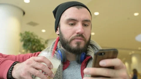 Young Man use Mobile Smart Phone browse Network at the Airport Terminal - Day Stock Footage 85314856