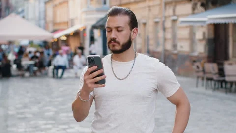 Young man use smartphone typing text messages browsing internet finishing work Stock Footage 247986909