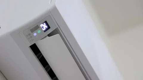 The young man used the air conditioning remote. Adjust the temperature to cool.  Stock Footage 153969667