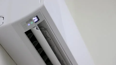 The young man used the remote to adjust the temperature of the air conditioner.  Stock Footage 153969668