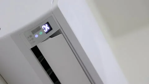 The young man used remote turn on the air conditioning . Adjust the temperature  Stock Footage 153969727