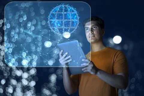 Young man uses digital tablet on virtual visual screen at night Stock Photos