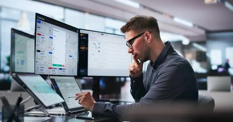 Young Man Uses Dual Touchscreen Laptops To Track Business Expenses Diligently Stock Photos