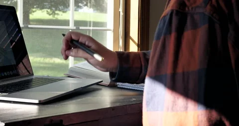 Young man uses multiple resources to complete school work. Video stock 141231312