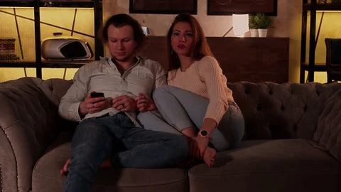 A young man uses a remote control to turn on the TV. Stock Footage 129600144