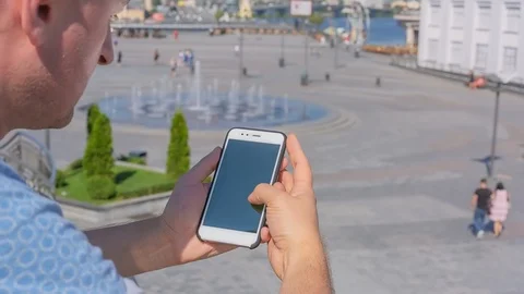 Young man uses SmartPhone with green screen staying in city square 1 Stock Footage 116409094