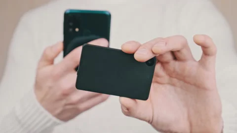 Young Man uses Smartphone to Scan QR Code on Cold Crypto Wallet for Transaction Stock Footage 198104058