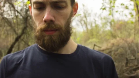 Young man uses a smartphone in a spring forest Video stock 80696795