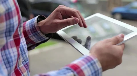 A young man uses tablet on a city street Stock Footage 63269938