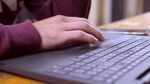 Young man uses touchpad on laptop with focused hands close-up Stock Footage 320257192