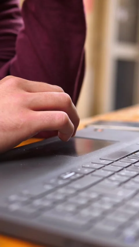 Young man uses touchpad on laptop with focused hands close-up Stock Footage 334774982