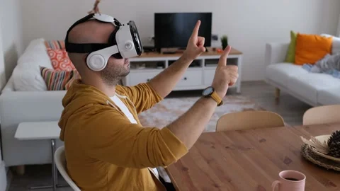 Young man using 3d vr glasses at his home. Young man navigating virtual tabs and Vídeo Stock 149136708