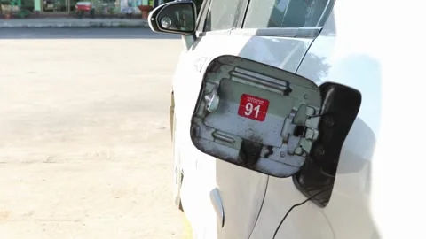Young man using and filling fuel into car standing at petroleum station. Stock Footage 256723509