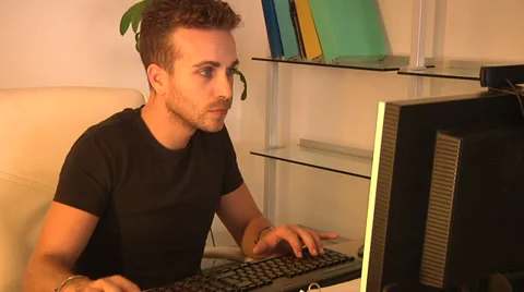 Young man using and typing on his computer. Stock Footage 31661994