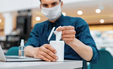 Young man using antiseptic wipes in the workplace Stock Photos