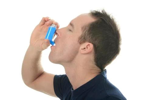 Young man using  an asthma inhaler as prevention Stock-Fotos
