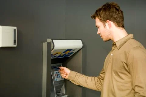 Young man using an ATM Stock Photos