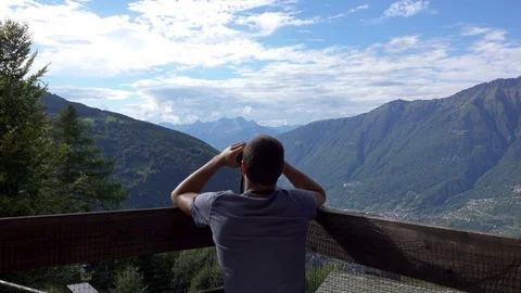 Young Man Using Binoculars Watching Mountain Field Stock Footage 79004494