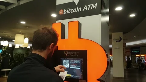Young man using bitcoin atm located inside a shopping center Vidéo 119173270