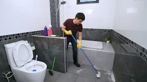 Young man using brush to cleaning the tile in the bathroom Stock-Footage 153726465