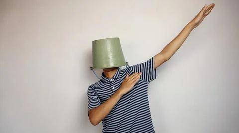 Young man using a bucket on his head on a white background. showing active .. 写真素材
