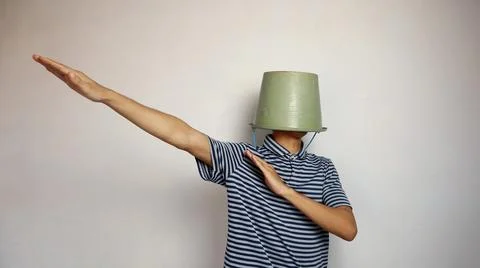 Young man using a bucket on his head on a white background. showing active .. Fotos de archivo