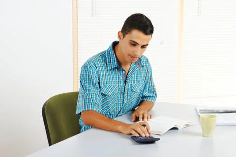 Young man using a calculator Foto stock