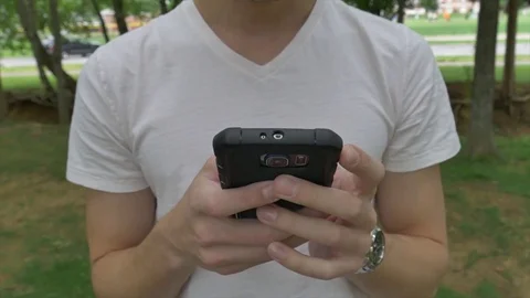 Young man using a cell phone outside 스톡 동영상 76452593