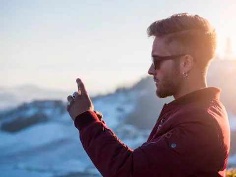 Young man using cell phone outdoor in winter fashion Stock Photos